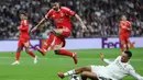 Hasil imbang 1-1 bertahan hingga waktu turun minum. Tampak dalam foto, gelandang SL Benfica, Rafa Silva, melompati bek Real Madrid asal Inggris, Trent Alexander-Arnold, selama pertandingan leg kedua babak playoff 16 besar Liga Champions 2025/2026 di Stadion Santiago Bernabeu pada Rabu 25 Februari 2026 waktu setempat atau Kamis (26/2/2026) dini hari WIB. (Thomas COEX/AFP)