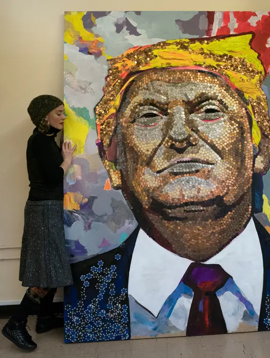 Seniman Ukraina Daria Marchenko berpose disamping lukisan Presiden AS Donald Trump di Akademi St George di New York (30/1). Lukisan ini dibuat dengan menggunakan dari sen dolar AS, nickels dan dimes. (AFP Photo/Don Emmert)