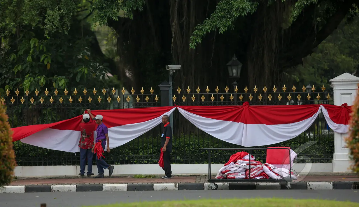 Sejumlah pekerja sibuk memasang kain berwarna merah putih dipagar depan Istana Merdeka Jakarta, Senin (13/4/2015). Jelang Konferensi Asia Afrika (KAA) ke-60 di Bandung pada 24 April mendatang, Istana Merdeka mulai dipercantik. (Liputan6.com/Faizal Fanani)