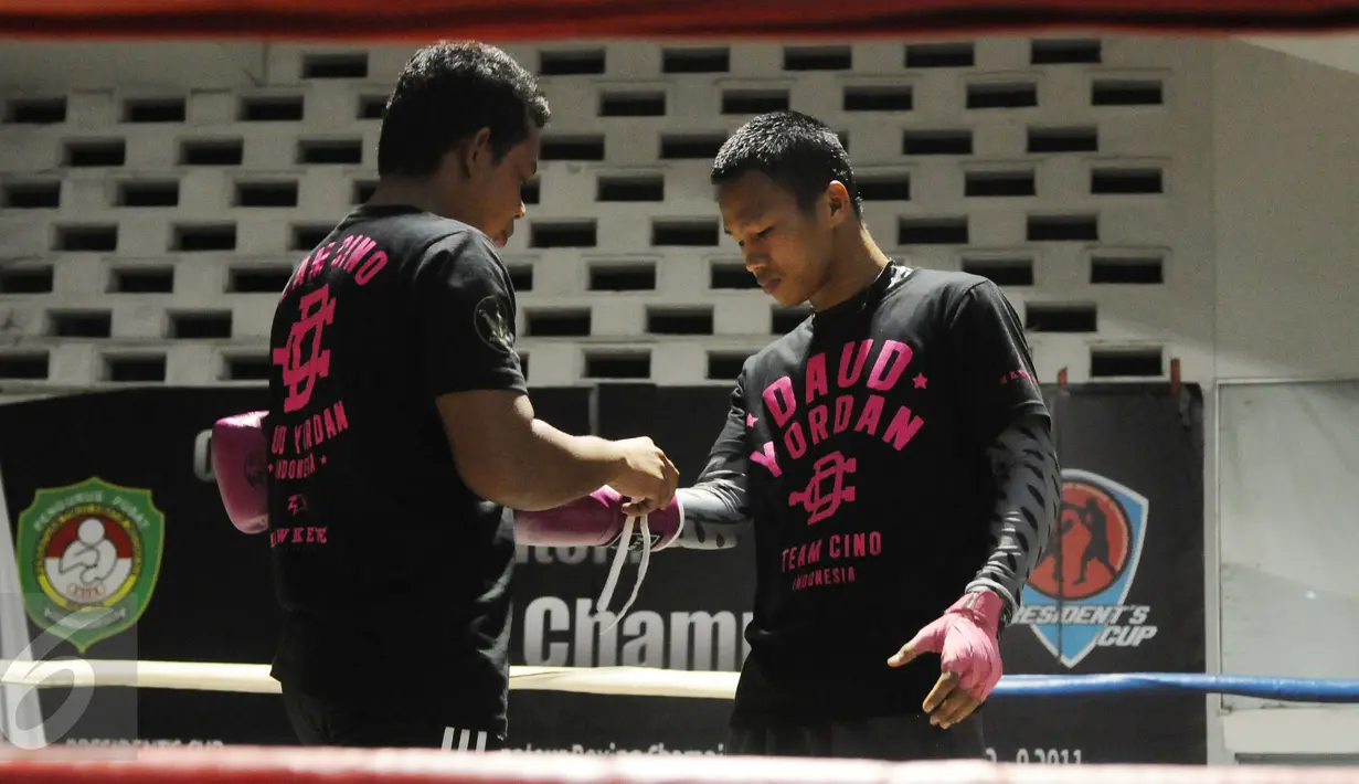 Petinju Indonesia, Daud Yordan (kanan) memasang sarung tinju saat berlatih di PB Pertina, Jakarta, Rabu (3/2/2016). Daud akan melawan Yoshitaka Kato dalam laga kelas ringan WBO "Road to the World Champions", Jumat (5/2). (Liputan6.com/Helmi Fithriansyah)