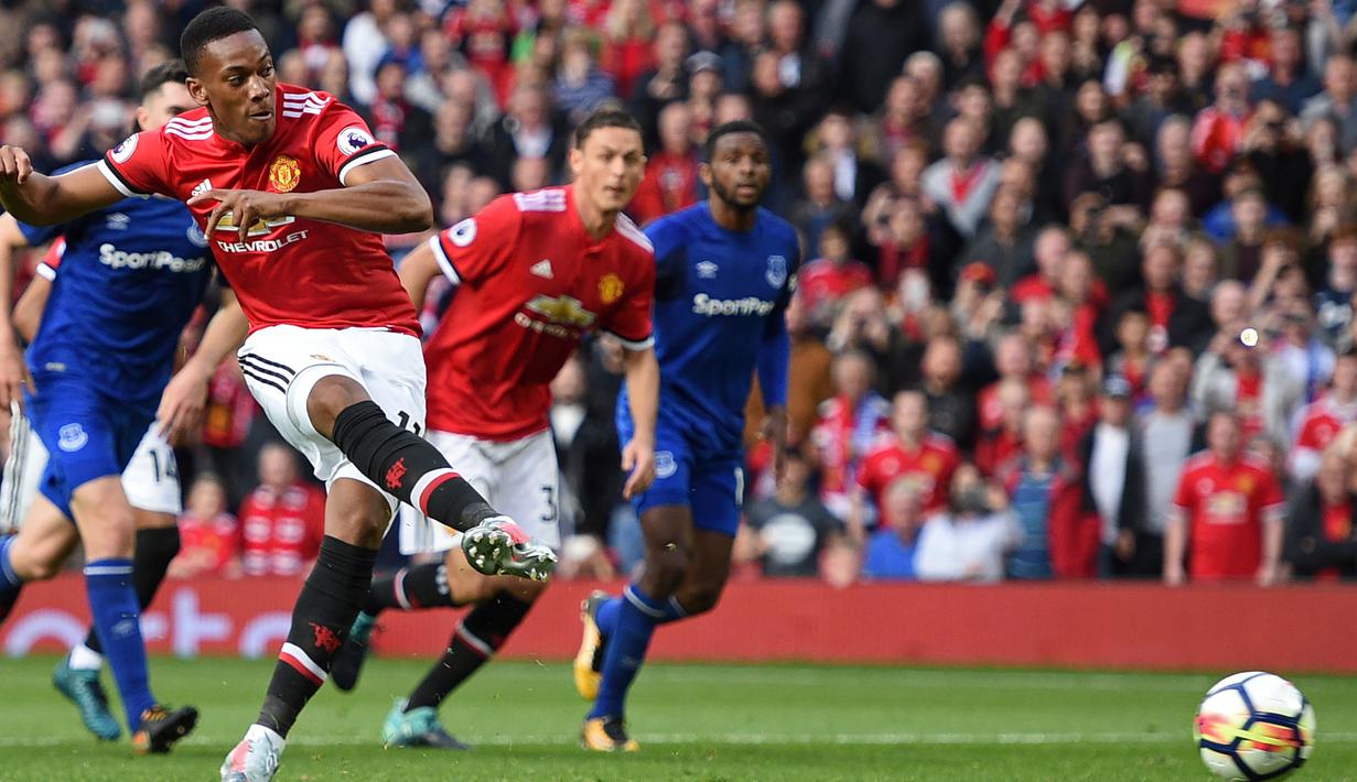 Pemain Manchester United, Anthony Martial mencetak gol lewat titik putih saat melawan Everton pada lanjutan Premier League di Old Trafford, Manchester (17/9/2017). Manchester United menang 4-0.  (AFP/Oli Scarff)
