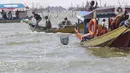 Sejumlah nelayan bersiap untuk melarung replika kapal berisi sesaji di Pantai Tarumajaya, Kabupaten Bekasi, Jawa Barat, Jumat (28/1/2022). Ritual dilakukan sebagai bentuk rasa syukur kepada Tuhan atas berlimpahnya hasil laut. (Liputan6.com/Herman Zakharia)
