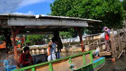 Warga tampak akan menaiki perahu untuk menyeberangi Kali Angke, Jakarta, Kamis (25/2). Para pemilik perahu getek mematok harga Rp2.000 untuk sekali sebrang. (Liputan6.com/Faisal R Syam)
