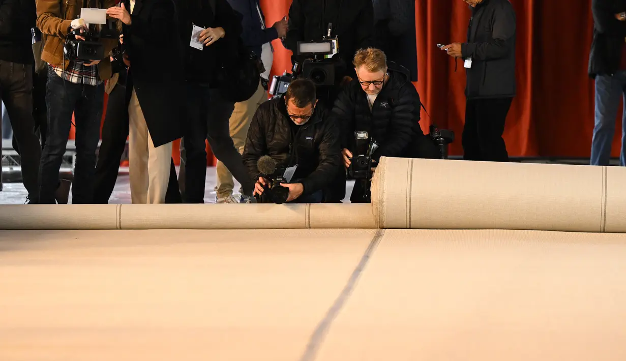 Karpet berwarna sampanye untuk area kedatangan karpet merah Oscar 2023 dibentangkan di sepanjang Hollywood Boulevard selama persiapan Academy Awards ke-95 di Los Angeles, California, Rabu (8/3/2023). Sederetan aktor dan aktris ternama seperti Riz Ahmed, Emily Blunt, Michael B. Jordan, Samuel L. Jackson, dan masih banyak lagi dijadwalkan hadir sebagai pembawa acara yang akan mengumumkan para pemenang tahun ini. (Patrick T. Fallon / AFP)