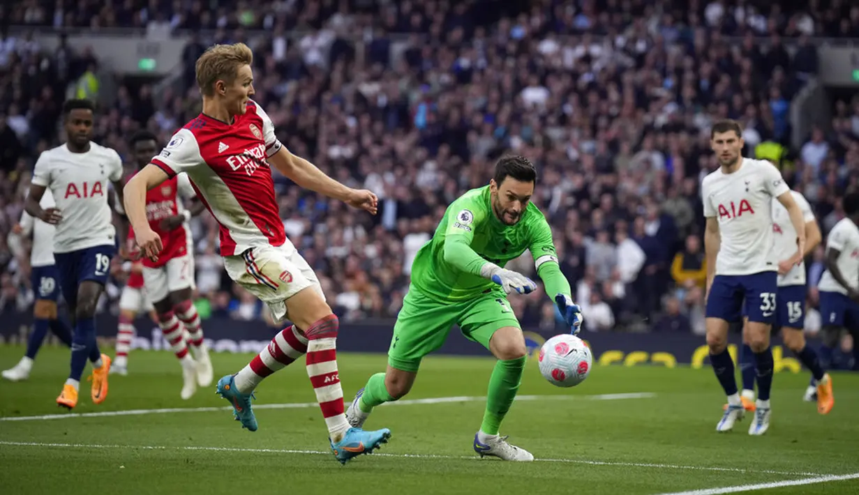 Penjaga gawang Tottenham Hotspur Hugo Lloris berebut bola dengan pemain Arsenal Martin Odegaard (kiri) pada pertandingan sepak bola Liga Inggris di Stadion Tottenham Hotspur, London, Inggris, 12 Mei 2022. Tottenham Hotspur menang 3-0. (AP Photo/Matt Dunham)