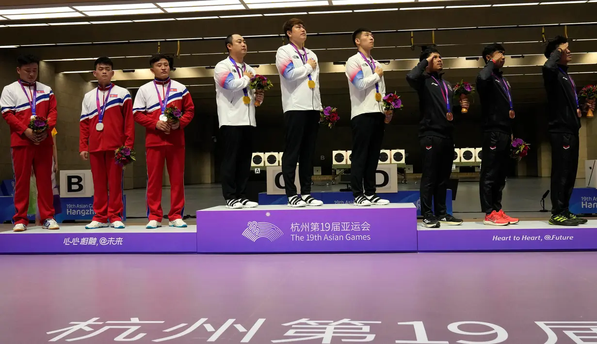 Tim peraih medali berdiri untuk menyanyikan lagu kebangsaan Korea Selatan saat upacara penghargaan menembak pistol cepat 25 meter beregu putra di Fuyang Yinhu Sports Centre dalam Asian Games ke-19 di Hangzhou, China, Senin, 25 September 2023. (AP Photo/Aijaz Rahi)
