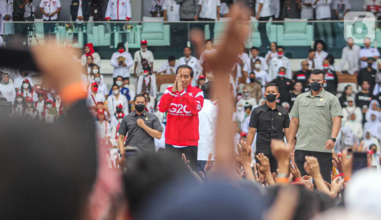 Presiden Joko Widodo (tengah) menyapa relawan saat menghadiri acara Gerakan Nusantara Bersatu: Satu Komando Untuk Indonesia di Stadion Utama Gelora Bung Karno, Jakarta, Sabtu (26/11/2022). Gerakan Nusantara Bersatu dari berbagai elemen relawan Jokowi itu untuk menyelaraskan persepsi barisan satu komando di bawah arahan Presiden Joko Widodo. (Liputan6.com/Faizal Fanani)