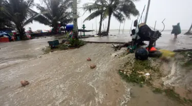 Banjir meluap di atas jalan pantai ketika Badai Tropis Pabuk mendekat di Pak Phanang, di Nakhon Si Thammarat, Thailand Selatan (4/1). Hujan, angin dan gelombang air laut akan melanda Thailand selatan akibat badai tropis Pabuk. (AP Photo/Sumeth Panpetch)