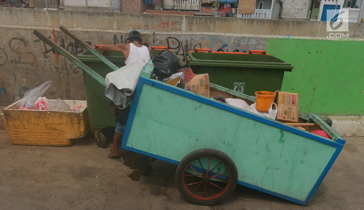 Pemulung mengambil sampah di tong sampah asal Jerman di kawasan Kampung Pulo, Jakarta, Selasa (5/6). Tong sampah asal Jerman tersebut berkapasitas 660 liter dengan total anggaran Rp 9,6 miliar untuk 2.600 tempat sampah. (Merdeka.com/Imam Buhori)