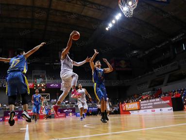 Pemain CLS Knight, Rachmad Febri Utomo melakukan lay up saat dihadang pemain Satya Wacana pada perempat final Playoffs Indonesia  Basket League (IBL) di Britama Arena, Jakarta, Selasa (17/5/2016). (Bola.com/Nicklas Hanoatubun)