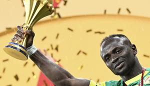 Penyerang Senegal, Sadio Mane, mengangkat trofi sambil merayakan kemenangan bersama rekan-rekannya setelah menjuarai Piala Afrika dengan mengalahkan  Maroko di Stadion Prince Moulay Abdellah, Rabat, Senin (19/1/2026) dini hari WIB. (AFP/Sebastian Bozon)