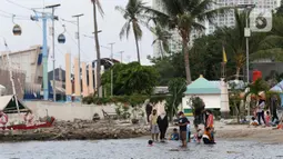 Pengunjung bersama anak-anak menikmati suasana Pantai Indah Taman Impian Jaya Ancol, Jakarta, Kamis (29/10/2020). Libur panjang di masa pemberlakuan PSBB transisi Jakarta dimanfaatkan warga untuk mengunjungi lokasi-lokasi wiisata. (Liputan6.com/Helmi Fithriansyah)