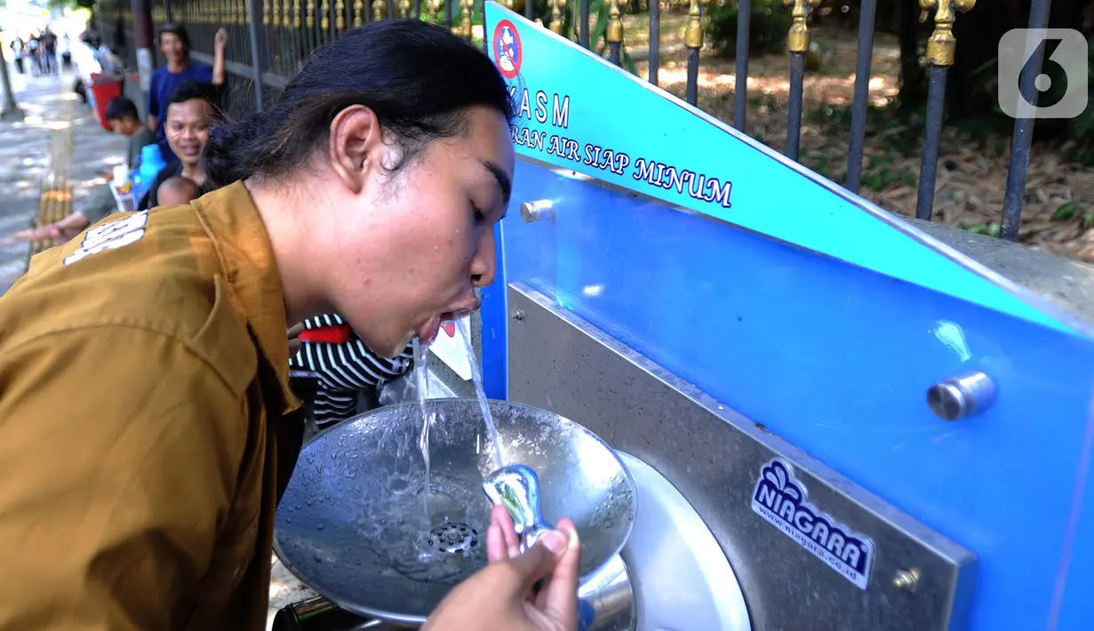 Warga minum dari Keran Air Siap Minum (KASM) yang terpasang di dekat Pintu 2 Kebun Raya Bogor, Jawa Barat, Minggu (6/10/2019). Pemkot Bogor melalui PDAM Tirta Pakuan membuat KASM di pendestrian Jalan Ir H Djuanda untuk menekan angka konsumsi botol dan gelas plastik. (merdeka.com/Arie Basuki)