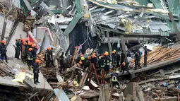 Petugas mencari korban yang tertimbun bangunan yang roboh di Kolombo, Sri Lanka, Kamis (18/5). Penyebab robohnya bangunan masih dalam tahap penyelidikan. (AFP/Ishara S. KODIKARA)
