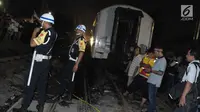 Petugas meminta warga untuk menjauhi lokasi kecelakaan di perlintasan Kramat, Senin, Jakarta, Selasa (13/6). Akibat dari kecelakaan ini, kondisi mobil hancur dan satu gerbong kereta api ikut terbakar. (Liputan6.com/Helmi Afandi)