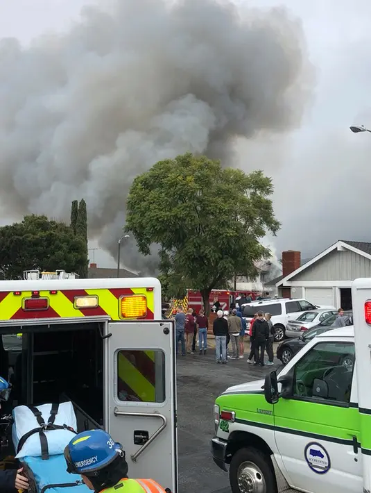 Warga melihat kobaran asap setelah pesawat Cessna 414A jatuh di sebuah rumah di Yorba Linda, California (3/2). Dilaporkan ada 4 orang tewas akibat kejadian ini, namun identitas korban belum diungkap. (AP Photo/Alex Gallardo)