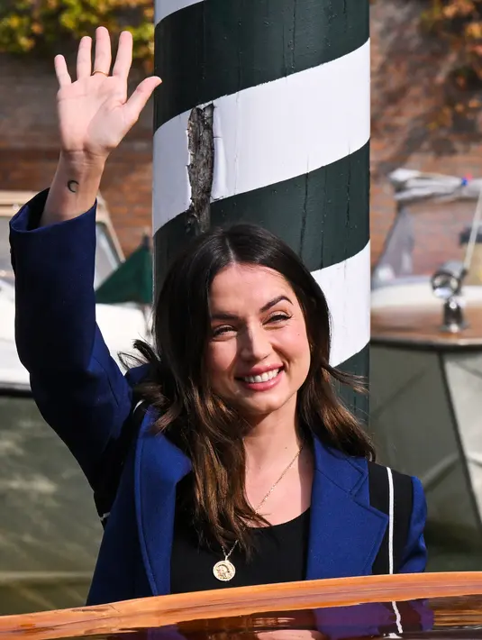 Ana de Armas melambaikan tangan saat tiba di dermaga Hotel Excelsior selama Venice Film Festival 2022 ke-79 di Lido di Venesia, Italia pada 7 September 2022. Ana de Armas memamerkan salah satu penampilan chic dari pakaian festivalnya saat dia memulai jejak promo untuk film Netflix.(AFP/Tiziana Fabi)