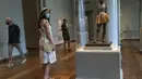 Pengunjung yang mengenakan masker melihat-lihat karya seni yang dipamerkan di Gedung Barat Galeri Seni Nasional di Washington DC, AS (20/7/2020). Sebagian galeri tersebut dibuka kembali untuk umum pada Senin (20/7) setelah ditutup selama berbulan-bulan akibat pandemi COVID-19. (Xinhua/Liu Jie)