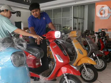 Pegawai gerai memberikan penjelasan kepada calon pembeli kendaraan bermotor listrik di Jatinegara, Jakarta, Rabu (29/5/2024). (Liputan6.com/Herman Zakharia)
