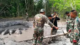 Polisi hutan mengevakuasi bayi gajah yang terperangkap dalam kolam lumpur di Taman Nasional Thap Lan, Provinsi Nakhon Ratchasima, Thailand, Kamis (28/3). Petugas mengevakuasi bayi-bayi gajah tersebut menggunakan batang pohon. (Department of Natural Park, Wildlife, and Plant Conservation via AP)