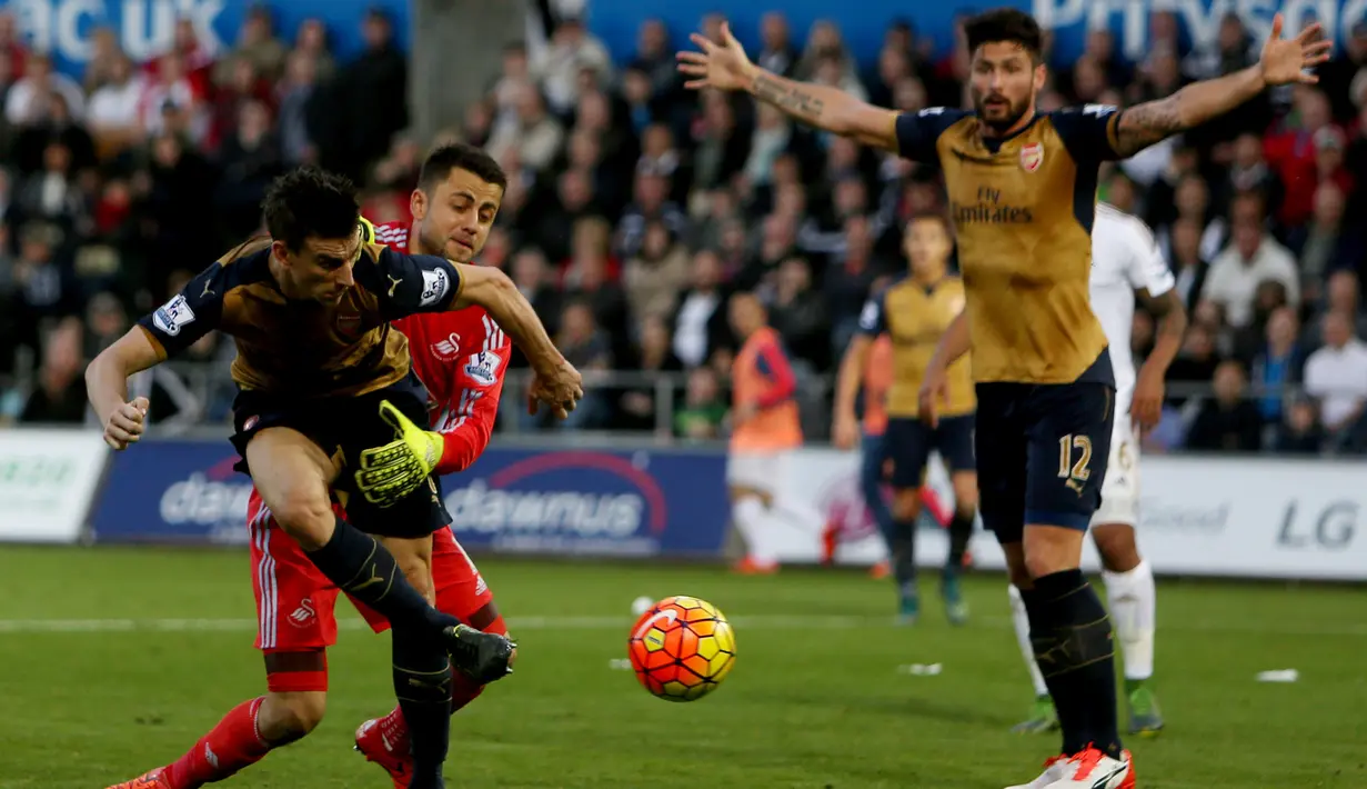 Laurent Koscielny berusaha dihentikan kiper Swansea City sebelum mencetak gol kedua Arsenal dalam lanjutan Liga Premier Inggris di Stadion Liberty, Sabtu (31/10/2015). (AFP Photo/Geoff Caddick)