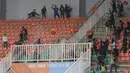Terlihat dua kelompok suporter Persib Bandung dan Persis Solo saling serang di antara tribune kosong yang jadi sekat keduanya. Kursi stadion terlihat beterbangan dan jadi objek penyerangan kedua kelompok suporter. (Bola.com/Bagaskara Lazuardi)