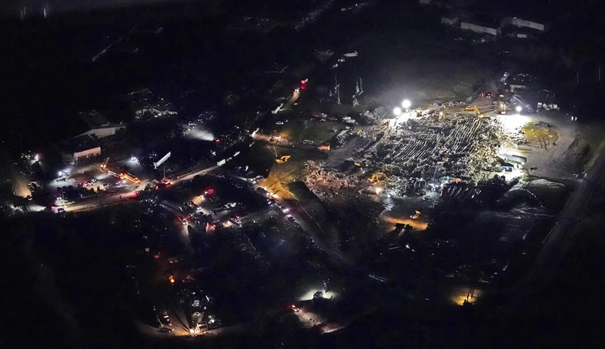 Para pekerja mencari korban selamat pada sebuah pabrik yang runtuh akibat diterjang tornado di Mayfield, Kentucky, Amerika Serikat, 11 Desember 2021. Gubernur Kentucky Andy Beshear mengatakan setidaknya empat tornado menghantam beberapa bagian Kentucky pada tengah malam. (AP Photo/Gerald Herbert)