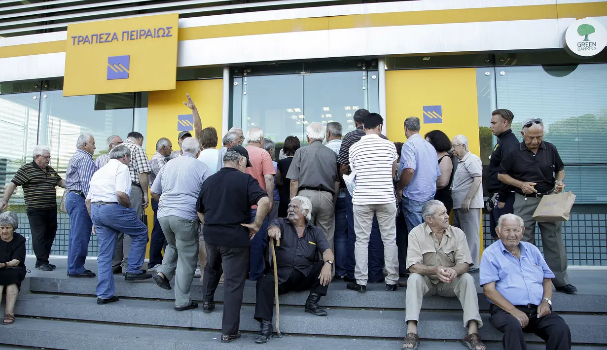 Sejumlah orang menunggu di pintu masuk Bank Piraeus di kota Iraklio, Yunani (20/7/2015). Pembukaan bank-bank di Yunani dilakukan usai Bank Sentral Eropa memberikan bantuan dana darurat senilai 900 juta euro. (REUTERS/Stefanos Rapanis) 