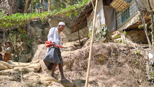 Seorang pengungsi di Kamp 14 Kutupalong, Cox's Bazar menuruni bukit tempat selter pengungsi didirikan (Liputan6.com/Rino Abonita)