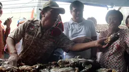 Wagub DKI Jakarta, Djarot Saiful Hidayat (baju putih) memilih kepiting saat blusukan ke Pasar Petak Sembilan, Jakarta, Sabtu (18/6). Selain berbincang-bincang Djarot juga memborong sejumlah sayuran yang dijual para pedagang. (Liputan6.com/Helmi Afandi)