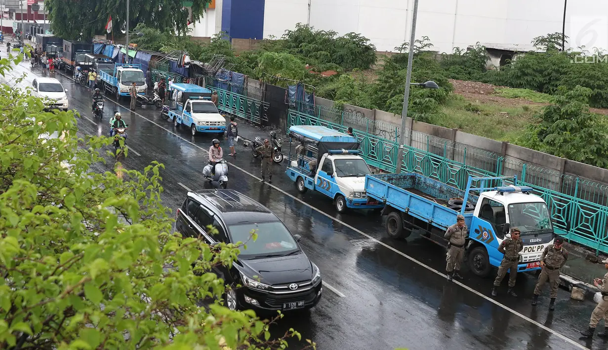 Personel Satpol PP berjaga di sekitar trotoar kawasan Senen, Jakarta, Kamis (22/11). Penjagaan itu menyebabkan trotoar di kawasan Senen bebas dari PKL yang biasa berjualan pakaian bekas. (Liputan6.com/Immanuel Antonius)