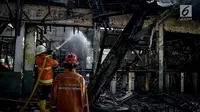 Petugas damkar melakukan pendinginan pasca terjadinya kebakaran di Stasiun Klender, Jakarta Timur, Jumat (19/5). Sembilan mobil pemadam kebakaran dikerahkan memadamkan api yang diduga berasal dari korsleting listrik tersebut. (Liputan6.com/Faizal Fanani)