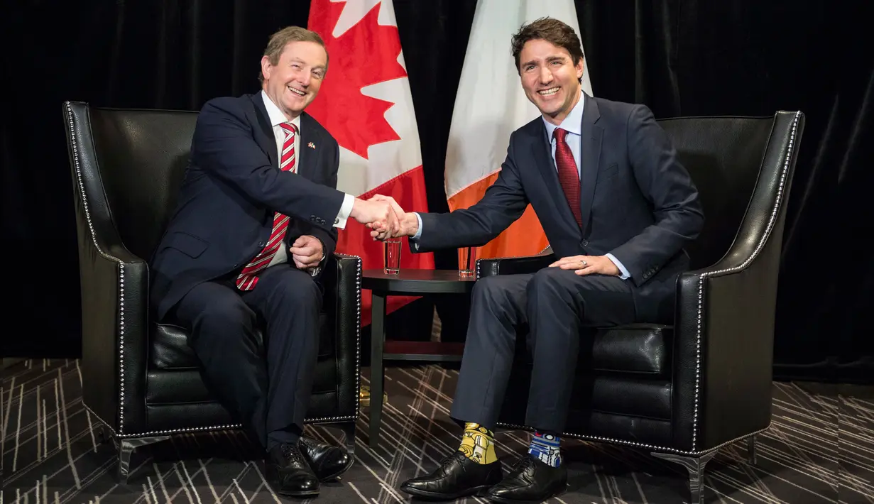 PM Kanada Justin Trudeau berjabat tangan dengan PM Irlandia, Enda Kenny sebelum menggelar pertemuan di Montreal, Kamis (4/5). Trudeau tampak mengenakan kaus kaki Star Wars dengan motif dan warna tak serasi. (Paul Chiasson/The Canadian Press via AP)