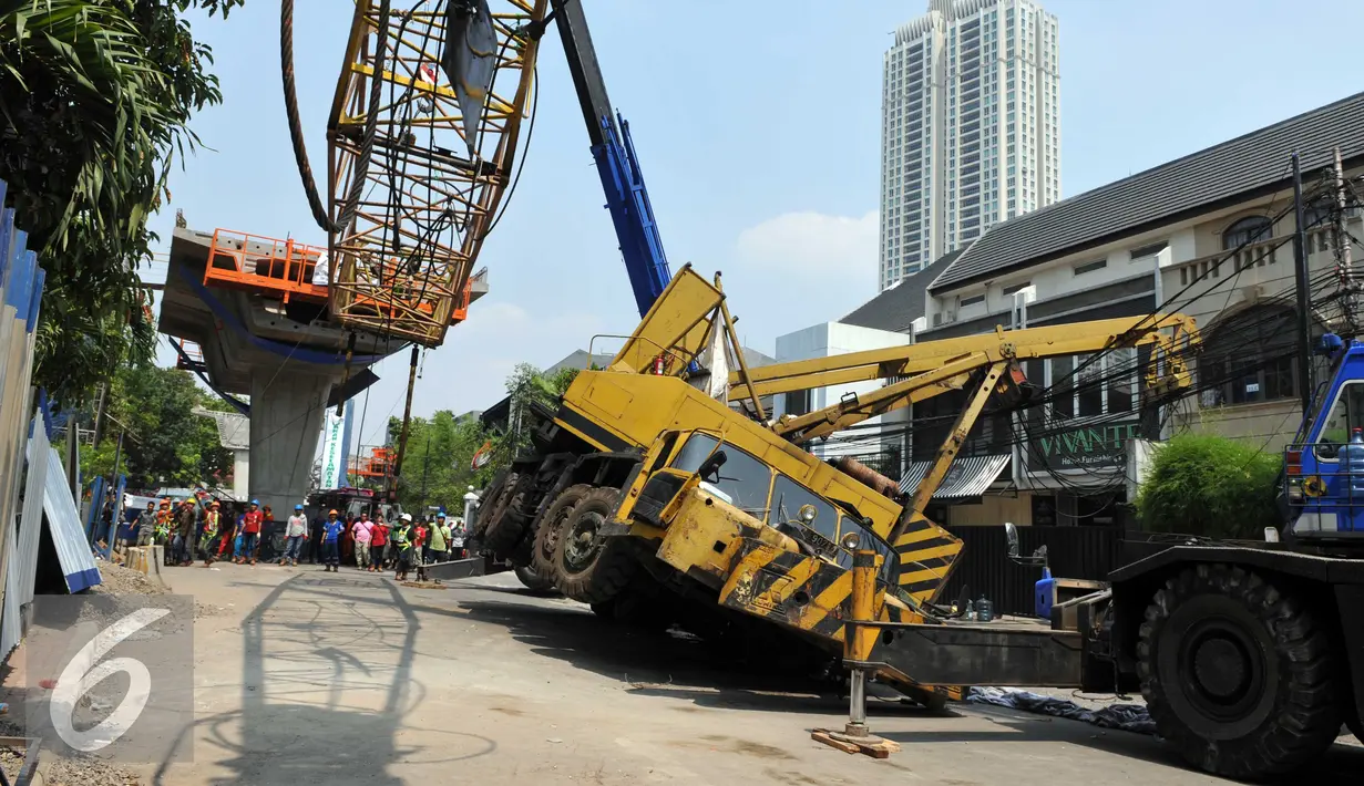 Pekerja mengevakuasi crane yang jatuh di Jalan Kyai Maja, Jakarta Selatan, Kamis (15/10/2015). Akibat kecelakaan ini, ‎lalu lintas di lokasi terganggu. Ruas Jalan Kyai Maja ditutup karena dilakukan pemindahan alat berat. (Liputan6.com/Helmi Afandi)