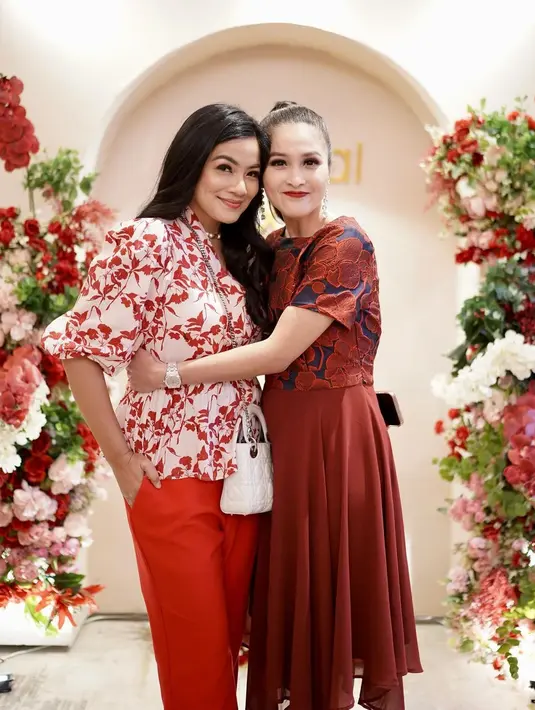 Titi Kamal kenakan atasan balloon sleeve dengan motif daun merah dan celana panjang merah. Tas Lady Dior putih yang jadi sling bag jadi sentuhan mahal di penampilan Titi Kamal [@sandradewi88]