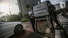 Petugas gabungan memasang plang penunjuk arah saat uji coba rekayasa lalu lintas di kawasan Bundaran HI, Jakarta Pusat, Senin sore (4/7/2022). Uji coba rekayasa lalu lintas dilaksanakan mulai hari ini, Senin 4 Juli hingga 10 Juli 2022 pukul 16.00-21.00 WIB. (Liputan6.com/Faizal Fanani)
