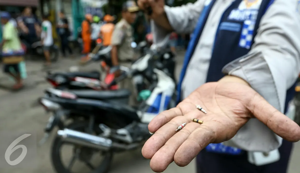 Petugas Dishub DKI menunjukan pentil ban dari kendaraan roda dua yang nekat parkir liar sehingga menyebabkan kemacetan di kawasan Senen, Jakarta, Selasa (29/3/2016). (Liputan6.com/Yoppy Renato)
