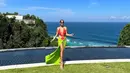 Selain dress, Indah juga kerap mengenakan bikini two piece warna neon dan bold saat liburan di pantai. @indahkalalo.