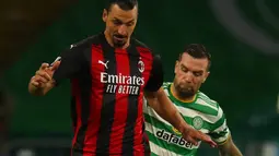Pemain AC Milan Zlatan Ibrahimovic (kiri) mengontrol bola di depan pemain Celtic Shane Duffy (kanan) pada pertandingan leg pertama Grup H Liga Europa di Celtic Park, Glasgow, Skotlandia, Kamis (22/10/2020). AC Milan menang 3-1. (Jane Barlow/Pool via AP)