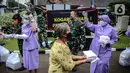 Warga membawa nasi kotak serta masker dari TNI di Markas Komando Gabungan Wilayah I, Jakarta, Selasa (21/4/2020). Dalam rangka Hari Kartini, TNI membagikan makanan dan masker kepada masyarakat. (Liputan6.com/Faizal Fanani)