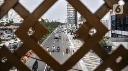 Lalu lintas kendaraan melintas di tengah penyelesaian proyek revitalisasi trotoar di Jalan Margonda Raya, Depok, Jawa Barat, Minggu (4/12/2022). Penataan trotoar di Jalan Raya Margonda, Depok, mengusung konsep instagramable. Konsep tersebut sebagai upaya meningkatkan minat masyarakat untuk berjalan kaki.(merdeka.com/Iqbal S Nugroho)