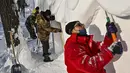 Para pria membangun rumah salju di Pameran Seni Patung Salju Internasional Harbin Sun Island menjelang Festival Es dan Salju Internasional Harbin Tiongkok ke-39 di Harbin, di provinsi Heilongjiang timur laut China (4/1/2023). (AFP/Hector Retamal)