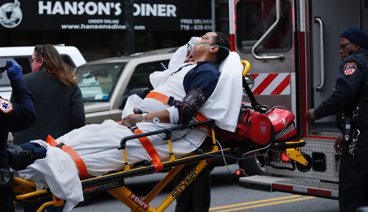 Seorang korban terluka di bawa menuju ambulans yang menunggu di depan Brooklyn Atlantic Terminal, New York, Rabu (4/1). Lebih dari 100 orang terluka akibat kereta komuter Long Island Road keluar jalur pada jam sibuk. (AFP PHOTO/Kena Betancur)