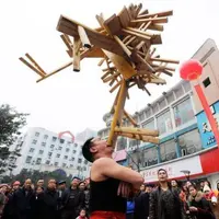 Li Hongxiao berhasil menyeimbangkan 24 bangku seberat 75 kg selama 10 detik hanya dengan menggunakan giginya. (via: People.com)