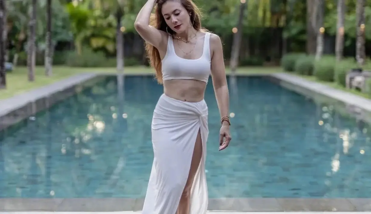 <p>Meski mengenakan sport bra, penampilan Wulan Guritno di potret ini tidak menunjukkan dirinya sebagai perempuan berusia 40an. Dipadukan dengan kain panjang yang diikat, Wulan Guritno berpose di pinggir kolam sembari memainkan rambut bronze-nya. (instagram/wulanguritno)</p>
