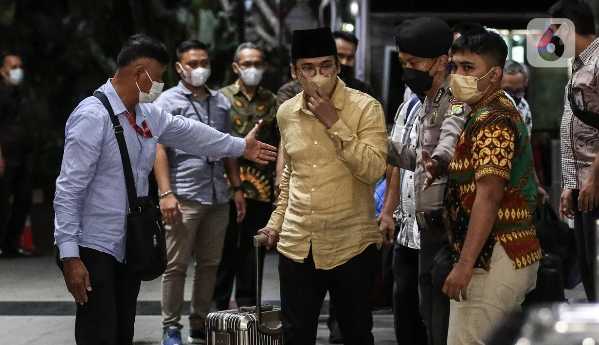 Bupati Bangkalan Abdul Latif Amin Imron membawa koper dan dikawal saat tiba di Gedung Komisi Pemberantasan Korupsi (KPK), Jakarta, Rabu (7/12/2022). KPK menangkap Bupati Bangkalan Abdul Latif Amin Imron sebagai tersangka kasus suap lelang jabatan di Pemerintahan Kabupaten Bangkalan, Jawa Timur. Total kekayaan yang dimiliki Abdul Latif sebanyak Rp 9,9 miliar. (Liputan6.com/Johan Tallo)