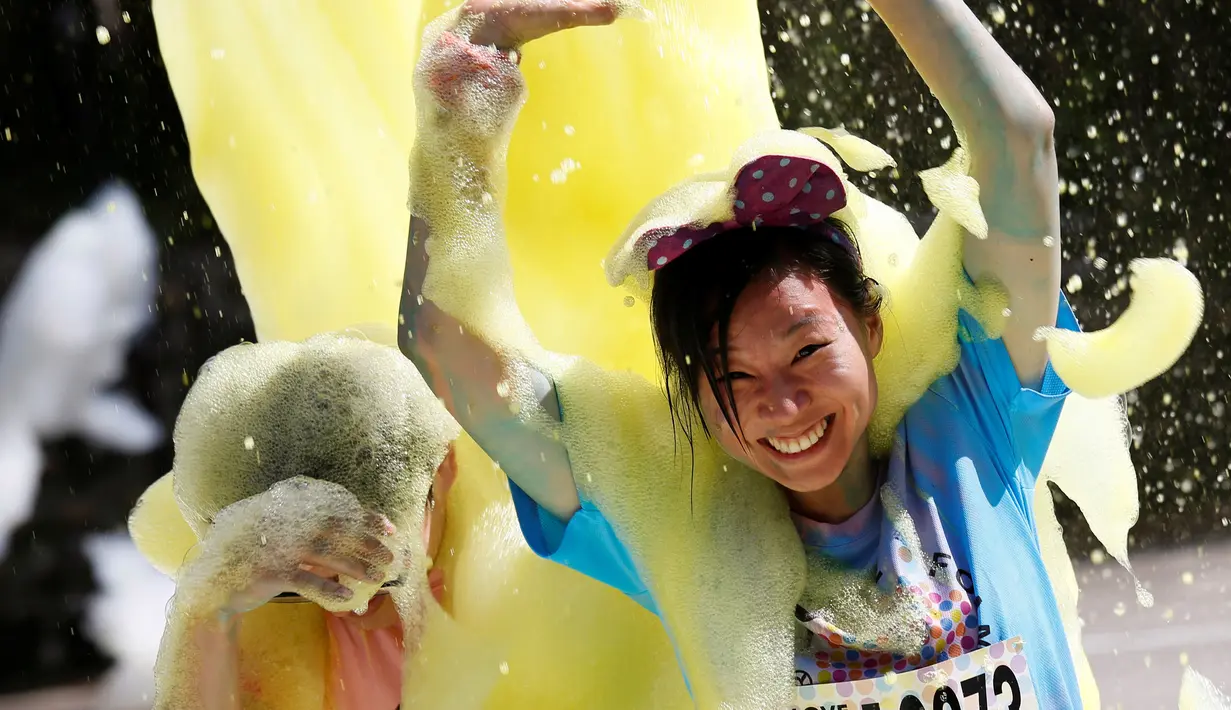 Peserta bermandi busa saat mengikuti Love Foam Run di Taiwan 29 Mei 2016. Sejmlah peserta berlari dan nantinya akan melalui tempat yang dipenuhi busa.( REUTERS / Tyrone Siu)