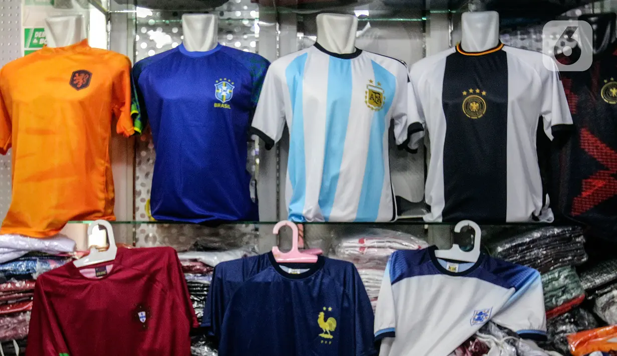 Jersey timnas sepak bola peserta Piala Dunia Qatar 2022 dipajang di salah satu kios Blok B Pasar Tanah Abang, Jakarta, Kamis (24/11/2022). Menurut pedagang, permintaan jersey timnas meningkat dikarenakan Piala Dunia Qatar 2022 yang dimulai sejak 20 November 2022. (Liputan6.com/Johan Tallo)