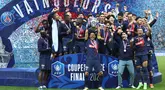 Bek Paris Saint-Germain #05 Marquinhos (tengah) mengangkat trofi Coupe de France 2023/2024 saat berselebrasi dengan timnya setelah menang atas Olympique Lyon pada laga final di Stadion Pierre-Mauroy, Minggu (26/5/2024) dini hari WIB. (FRANCK FIFE / AFP)