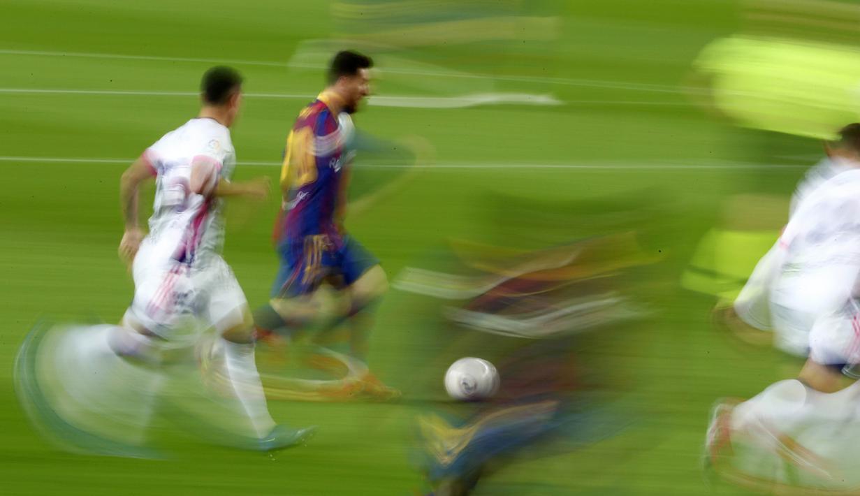 Striker Barcelona, Lionel Messi, menggiring bola melewati pemain Real Valladolid pada laga Liga Spanyol di Stadion Camp Nou, Selasa (6/4/2021). Barcelona menang dengan skor 1-0. (AP Photo/Joan Monfort)